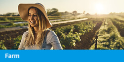 Farm elearning - Young woman standing in a field of vegetables in the morning light